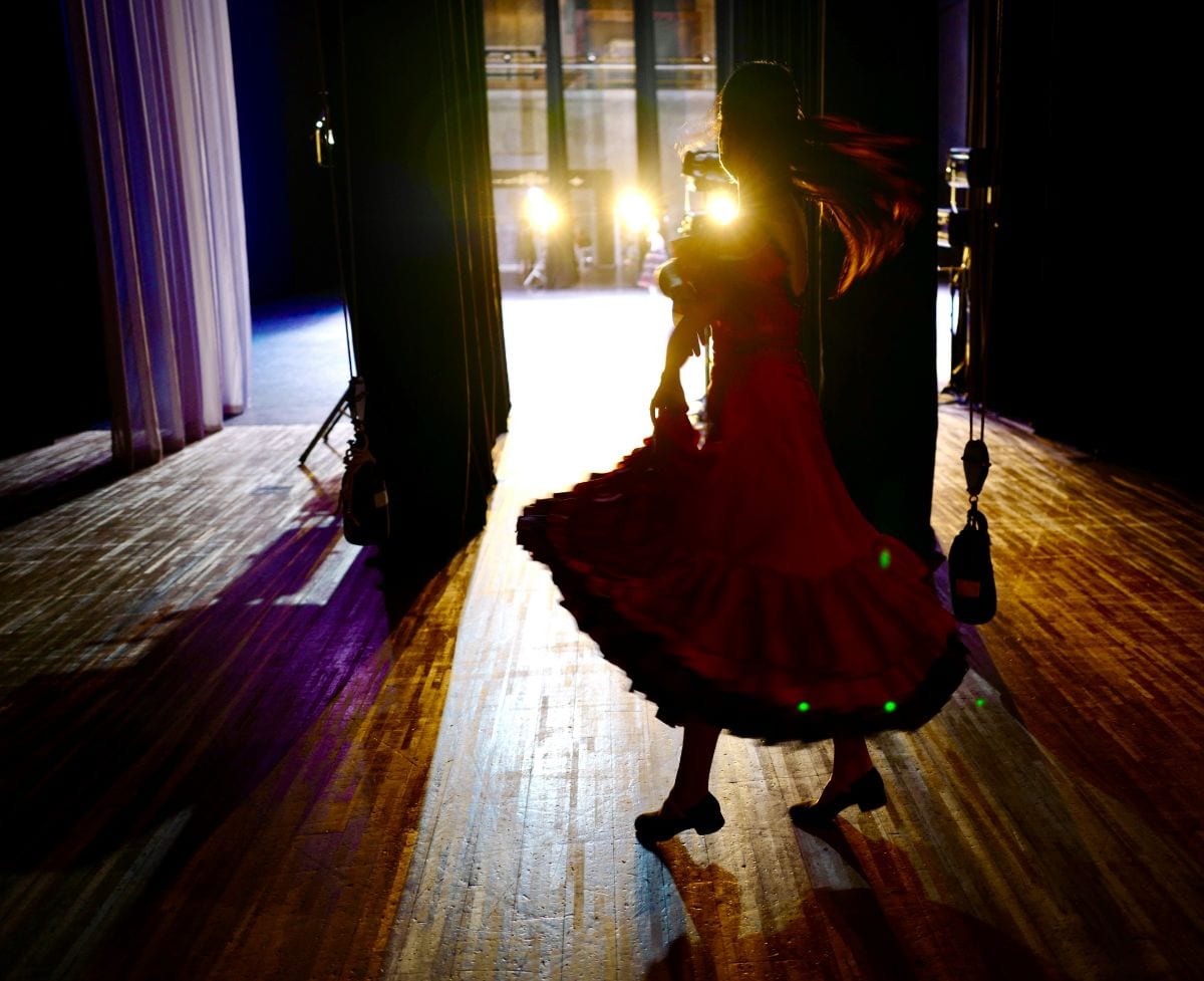 Danseuse de flamenco tournant dans la lumière de scène