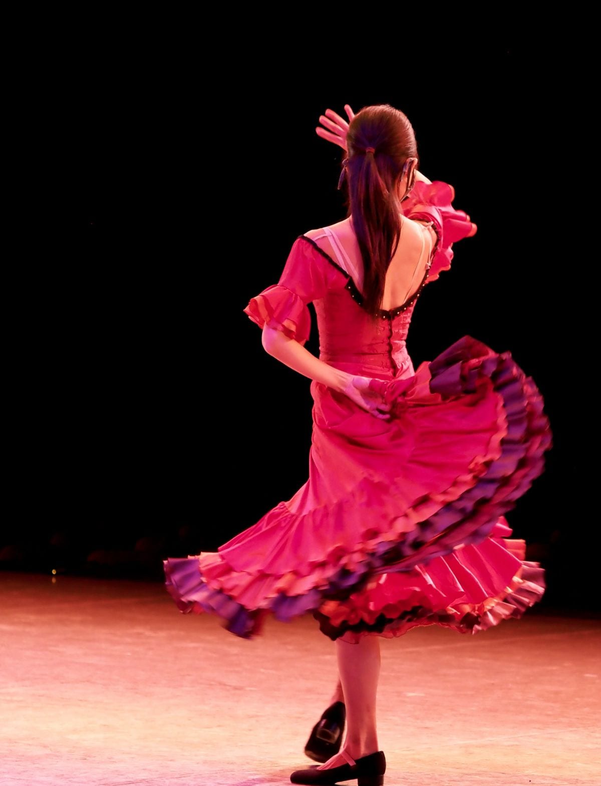 Danseuse de flamenco en robe rose tournant sur scène